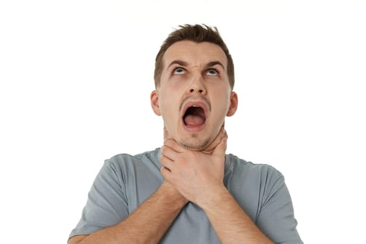 guy grimaces and grabs his throat with his hands on white background.