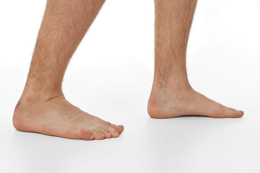 Barefoot male legs on white background. Body care concept.