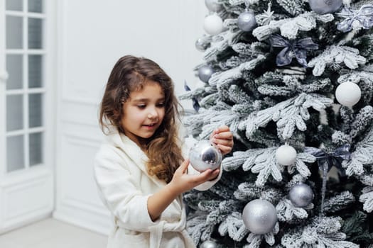 7-year-old girl at christmas tree with gifts and toys