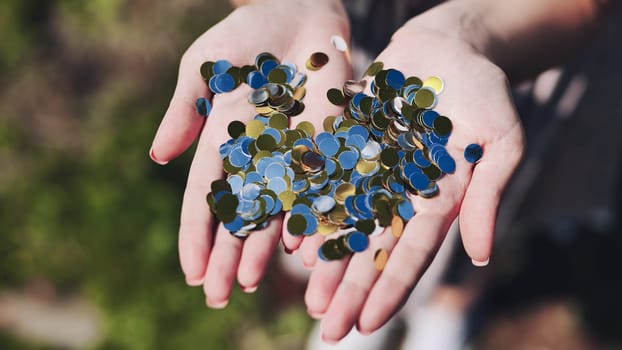 Gold and silver mirrored confetti in the girl's hands