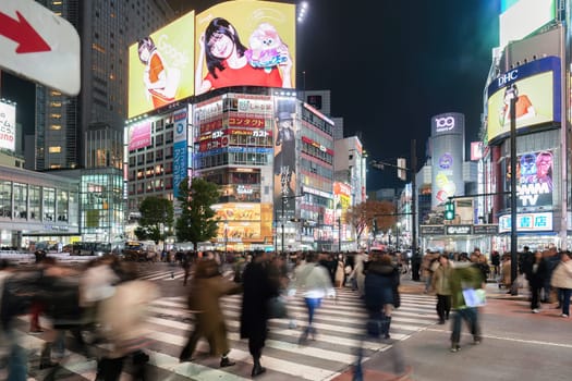 JAPAN - NOV 26, 2023 : Illumination of Advertising Signs at Night with Japanese people and Tourists walking across Shibuya Scramble Crossing, Shibuya, Tokyo.