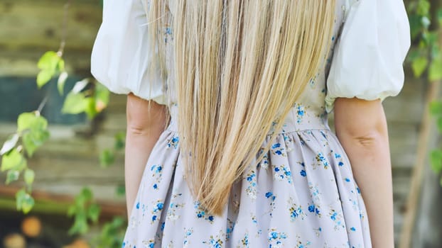 Blonde hair in a dress. View from the back