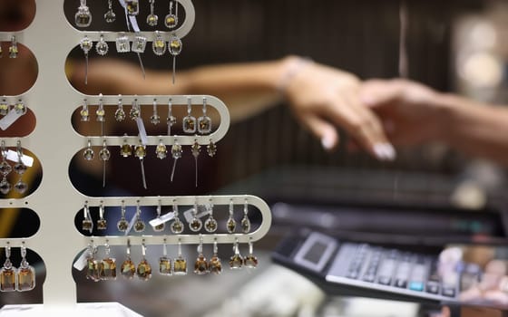 Lot of precious earrings with stones sold in jewelry store closeup. Jewelry and bijouterie concept