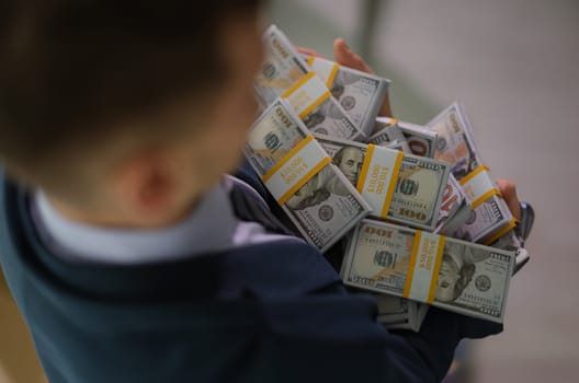 Banker holding in hands lot of packages with money closeup. Lottery win and business success concept