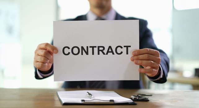 Hands of businessman holding contract document for employment at work in office closeup. Legal job placement concept