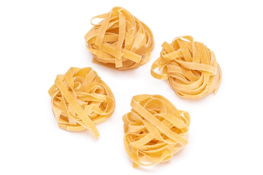 Four Classic Italian Raw Egg Fettuccine - Isolated on White Background. Dry Twisted Uncooked Pasta. Italian Culture and Cuisine. Raw Golden Macaroni Pattern - Isolation