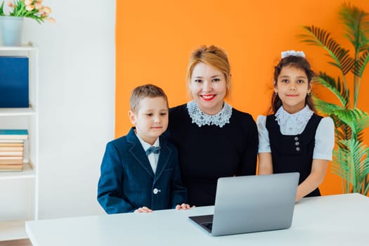 Female teacher teaching kids to work on computer online