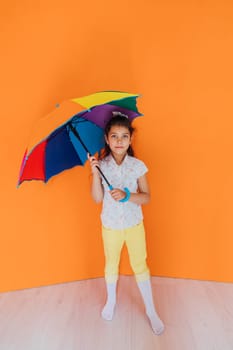 girl standing with colorful umbrella from the rain