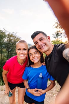 selfie photo of a happy sporty family in the nature, concept of outdoor activities with children and healthy lifestyle