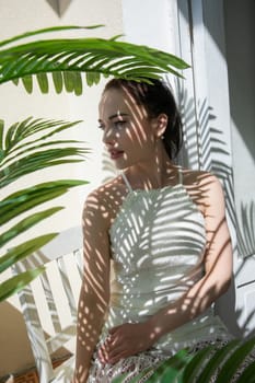 fashionable brunette woman and shadow from leaves in the sun