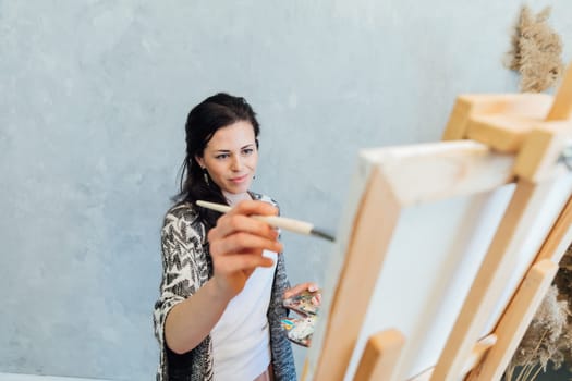 Woman painting with paints beautiful picture