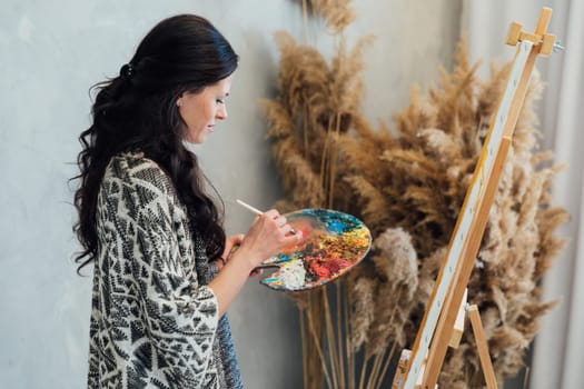Woman painting with paints beautiful picture