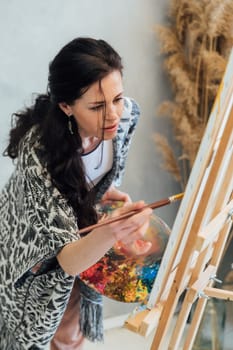 Woman painting with paints beautiful picture