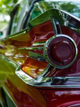 The back of a retro car from the 60s. Rear wing tail unit of red color retro car