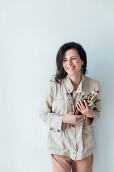 Photo of smiling good mood woman construction worker laughing hold paint brush isolated on yellow color background