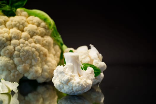 slices of raw small raw cauliflower isolated on black background