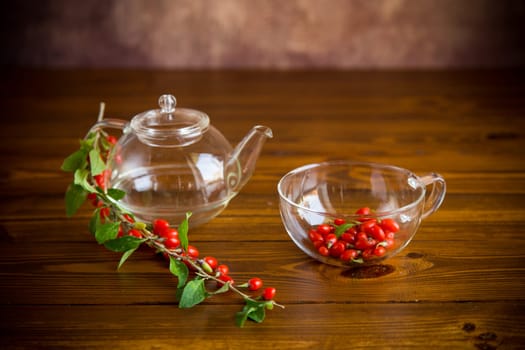 Branch with ripe red goji berry on a brown wooden table