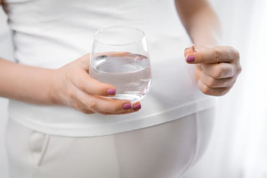 Pregnant woman takes pills during pregnancy. Illnesses, lack of vitamins concept
