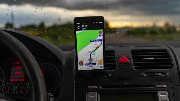 Smartphone showing Waze maps to show the way thru the city. Driver using Waze maps