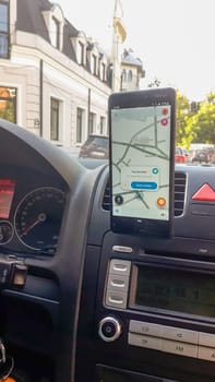 Smartphone showing Waze maps to show the way thru the city. Driver using Waze maps