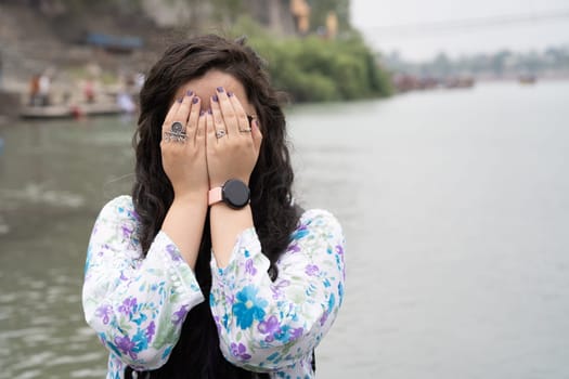 Young Indian woman hiding face wearing a ring saying musafir meaning traveller in India