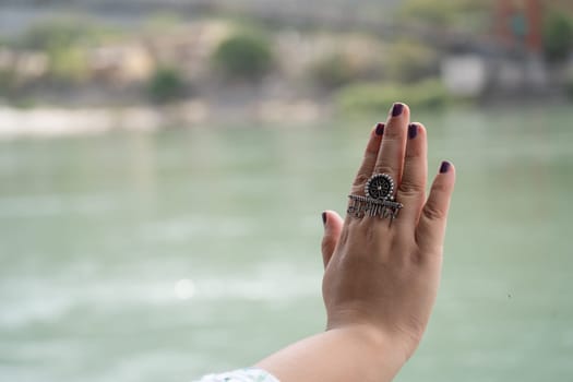 Hands of indian woman with purple nail polish and ring saying musafir meaning traveller in Hindi showing the trend of travelling across India