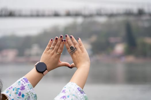 Hands of indian woman with purple nail polish and ring saying musafir meaning traveller in Hindi showing the trend of travelling across India