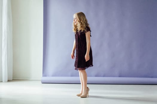 Girl of 10 years in a dress dances to the music alone in the room