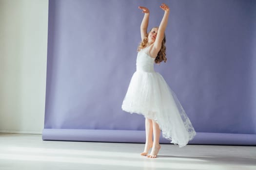 Girl of 10 years in a dress dances to the music alone in the room