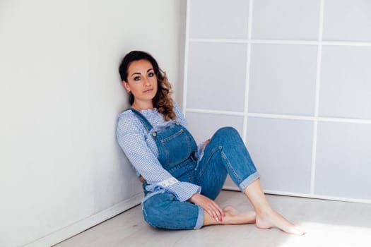 portrait of a woman in denim in a white room