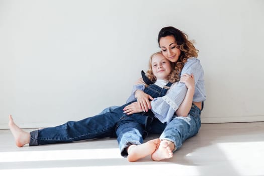 Mom and daughter in denim play in white family love