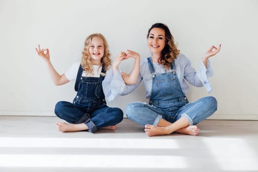 Mom and daughter in denim play in white family love