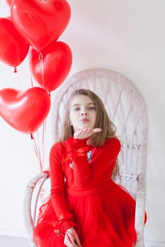 Little girl with red balloons for the holiday