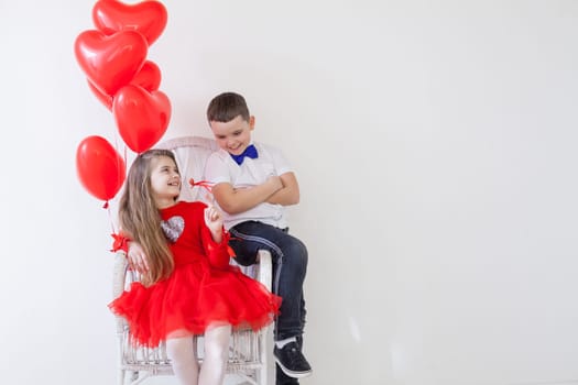 Boy and girl in a chair with balloons