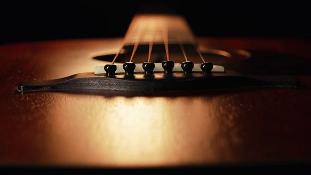 Macro of strings on redwood acoustic guitar fretboard. Classical music, sound background. High quality