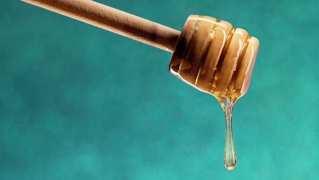 Organic honey flows from olive wood dipper stick spoon, tasty process. Apiary, beekeeping concept. Dripping, pouring sweet fluid nectar in slow motion. High quality