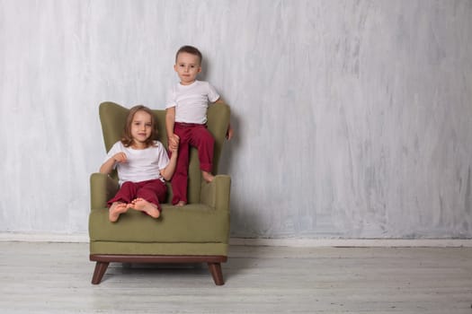 boy and girl sitting in a green chair in the room