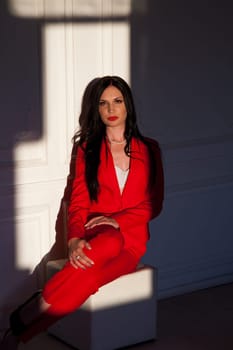 business woman brunette in a red business suit in the office