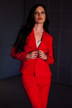 business woman brunette in a red business suit in the office