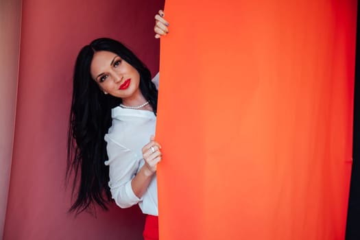 business woman brunette in a red business suit in the office