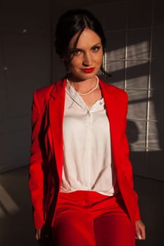 business woman brunette in a red business suit in the office