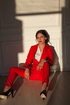 business woman brunette in a red business suit in the office