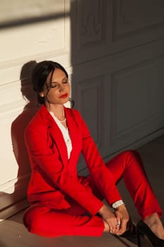 business woman brunette in a red business suit in the office