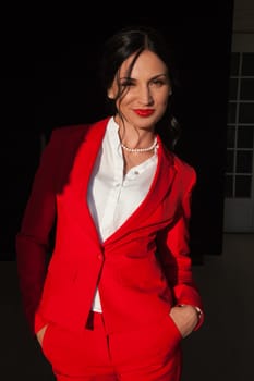 business woman brunette in a red business suit in the office