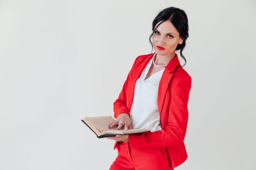 business woman brunette in a red business suit with a book