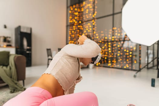 Engaging in fitness routines in a pink athletic attire while wearing a virtual reality headset near a Christmas tree. High quality photo