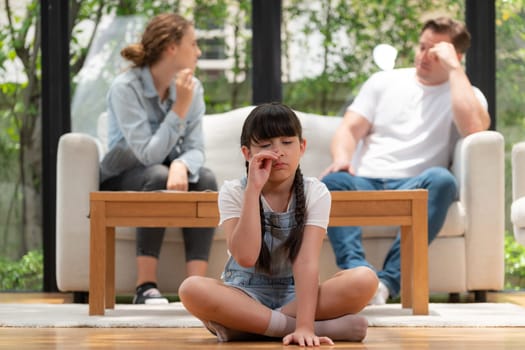 Stressed and unhappy young girl crying and trapped in middle of tension by her parent argument in living room. Unhealthy domestic lifestyle and traumatic childhood develop to depression. Synchronos