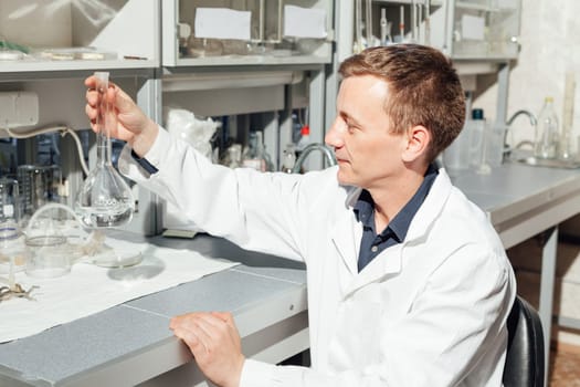 scientist conducts experiments with liquids in the medical laboratory