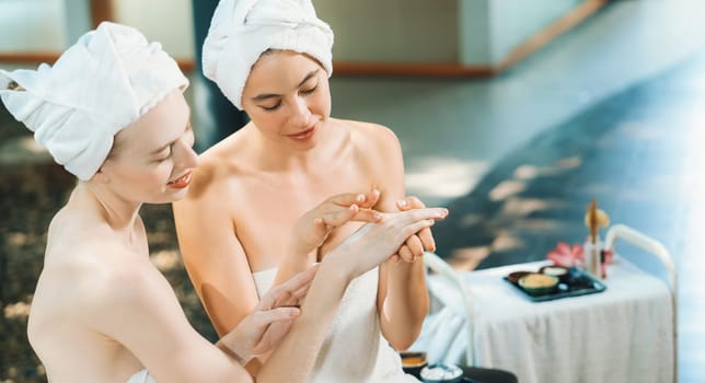 A portrait of two beautiful caucasian woman in white towel using homemade facial mask rounded by peaceful natural environment at outdoor. Healthy and beauty concept. Blurring background. Tranquility.