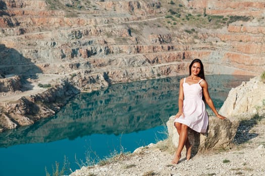 woman with long hair looks at the landscape from cliff trip